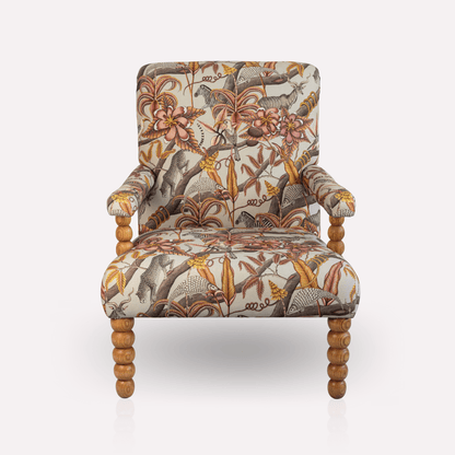 Front view of the Ardmore Kudu Pod Chair in Pangolin Plum Velvet, showcasing its high backrest, rich patterned upholstery, and sturdy oak legs