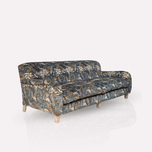 Showcasing the luxurious Pangolin Park Ash velvet upholstery with rich African-inspired patterns. The plush cushioning and elegant wooden legs highlight the blend of comfort and sophistication.