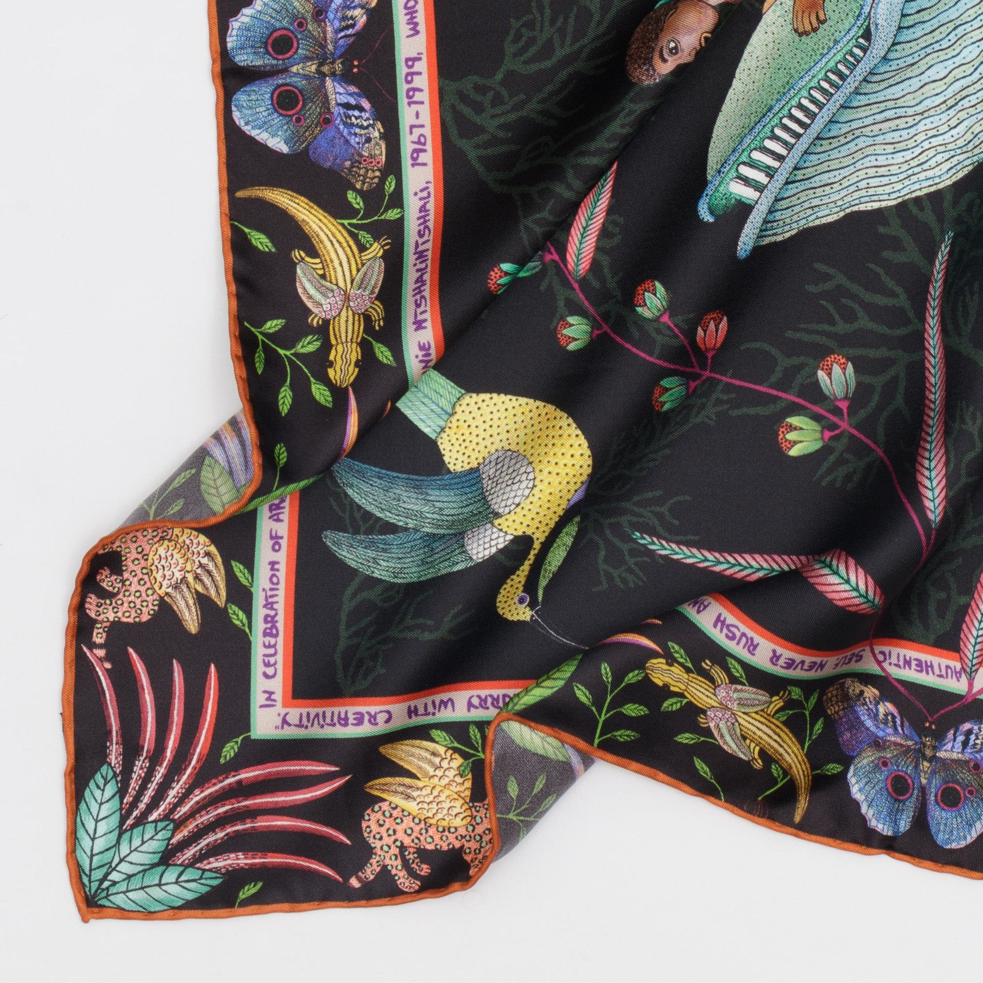 The scarf folded and arranged to highlight the luxurious feel of the silk, with a blend of deep and pastel tones creating an elegant contrast.