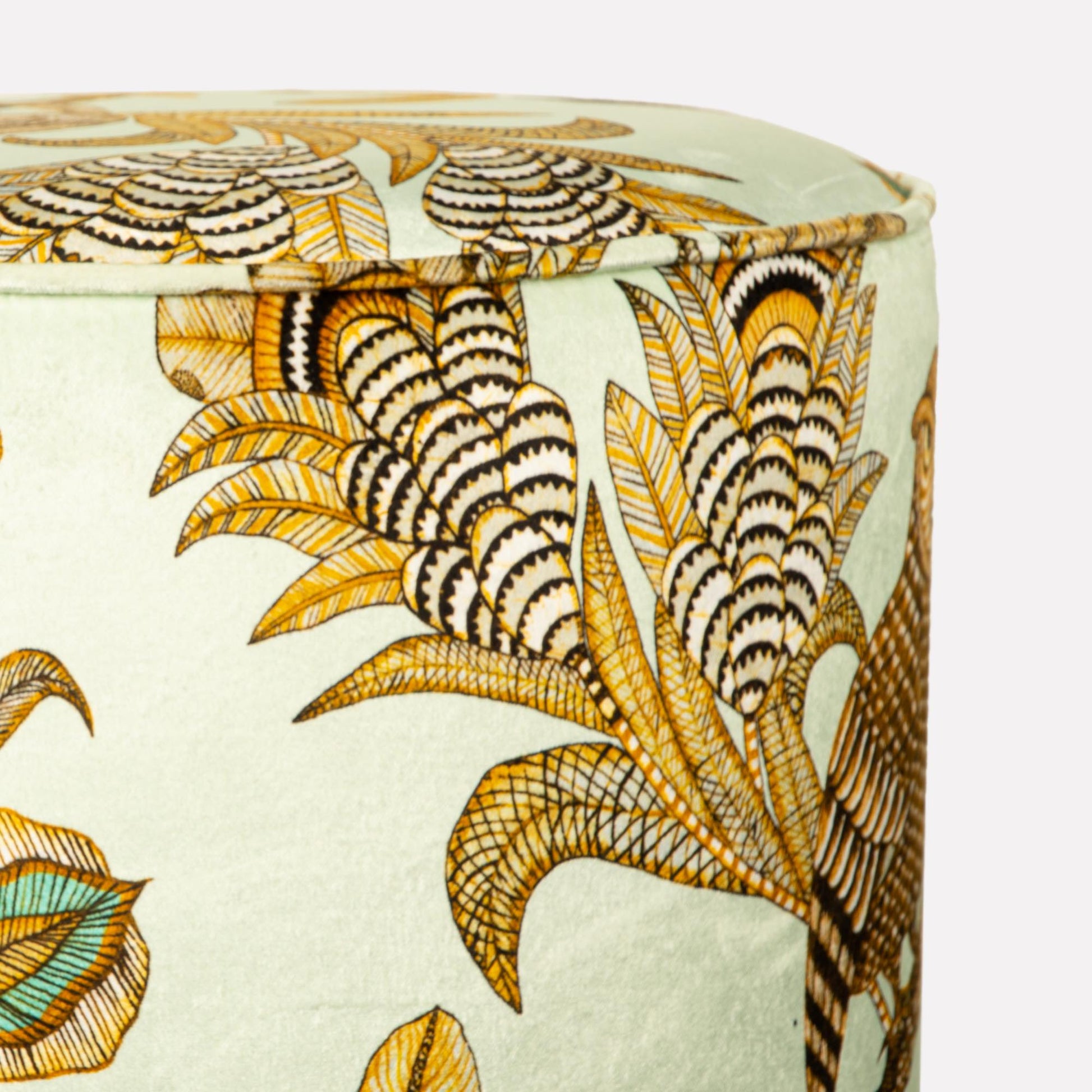 Close-up of the Ardmore Camp Critter Mist Velvet Pouffe’s side, emphasising the rich textures of the velvet fabric and the vibrant gold illustrations.
