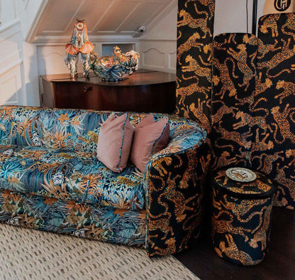 Interior setting featuring the Ardmore Cheetah Kings Amber Velvet Pouffe, beautifully integrated into a stylish living space alongside matching home decor pieces.