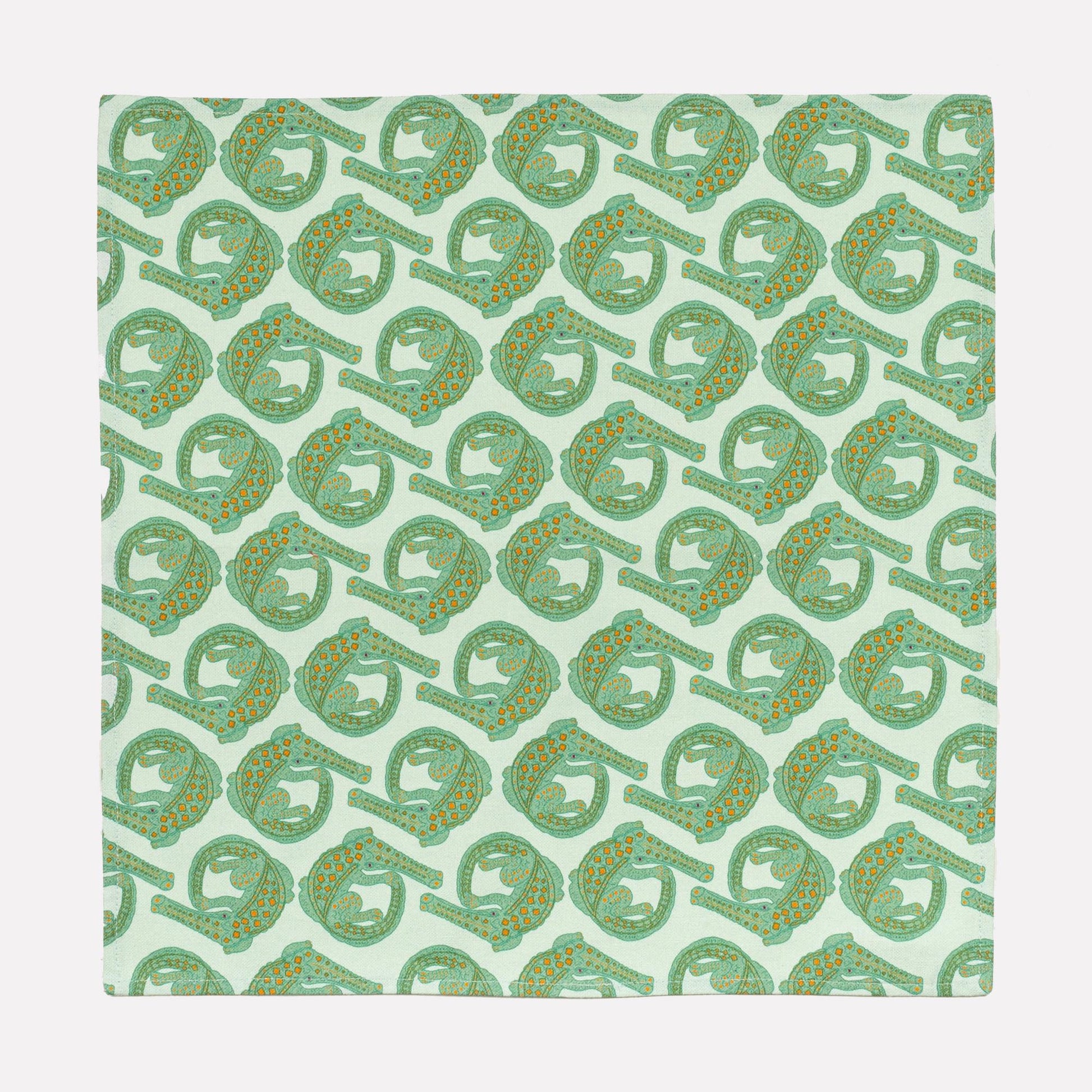 A full view of the Ardmore Croco napkin in Mist, showcasing the intricate repeating crocodile motif in a gentle green shade on a linen-cotton fabric blend.