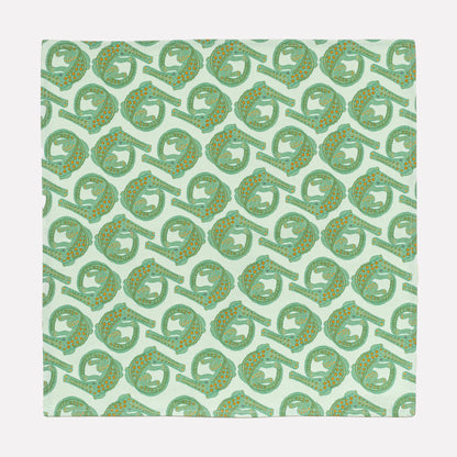 A full view of the Ardmore Croco napkin in Mist, showcasing the intricate repeating crocodile motif in a gentle green shade on a linen-cotton fabric blend.