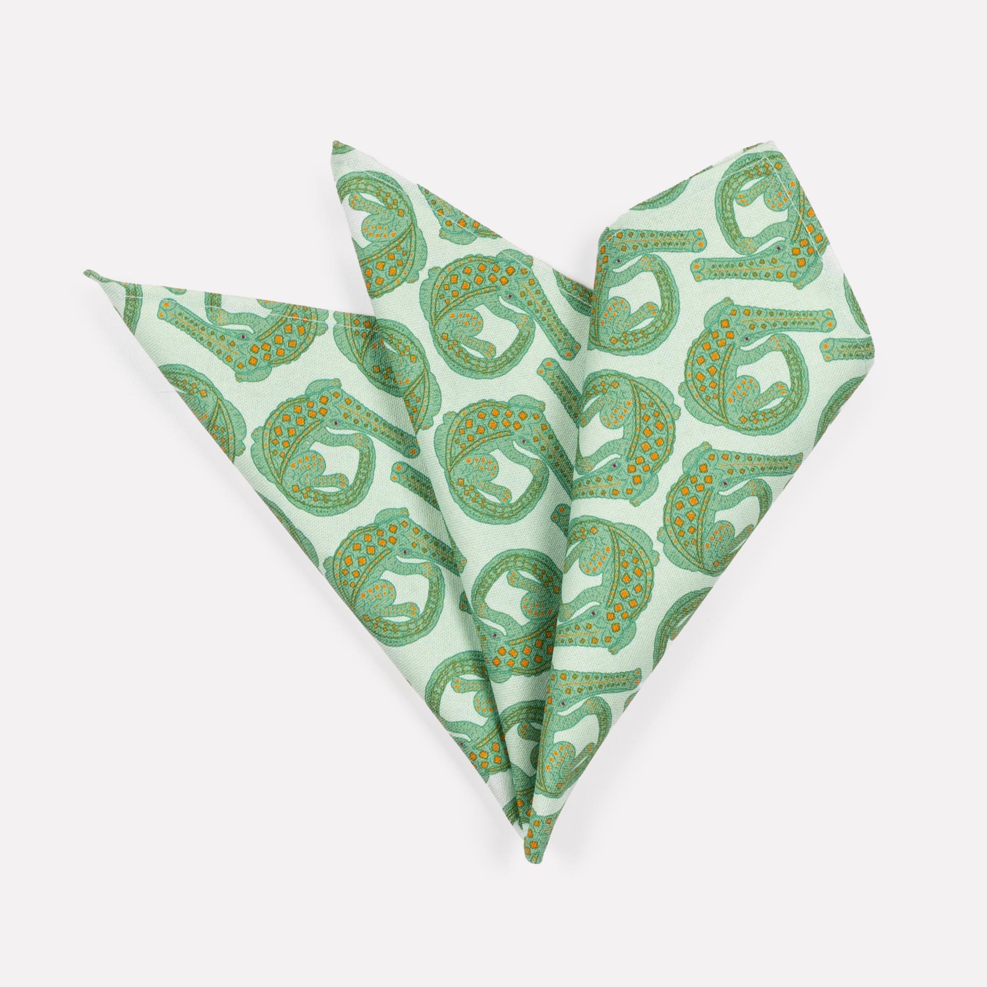 A pair of Ardmore Croco napkins in Mist, elegantly folded into a fan shape to highlight the delicate crocodile-inspired pattern in soft green hues.