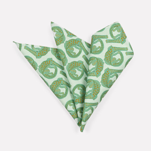 A pair of Ardmore Croco napkins in Mist, elegantly folded into a fan shape to highlight the delicate crocodile-inspired pattern in soft green hues.