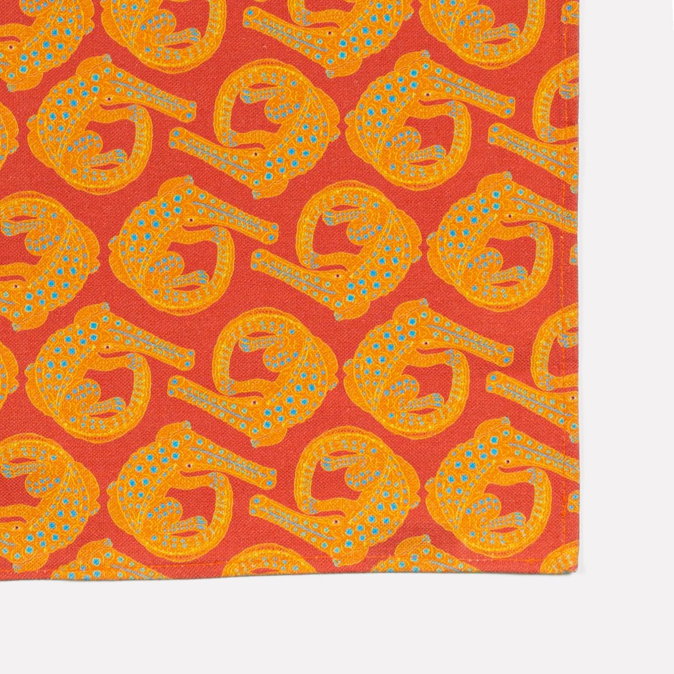 An extreme close-up of the Ardmore Croco napkin in Sunset, capturing the intricate crocodile motif and the fine texture of the premium linen-cotton blend.