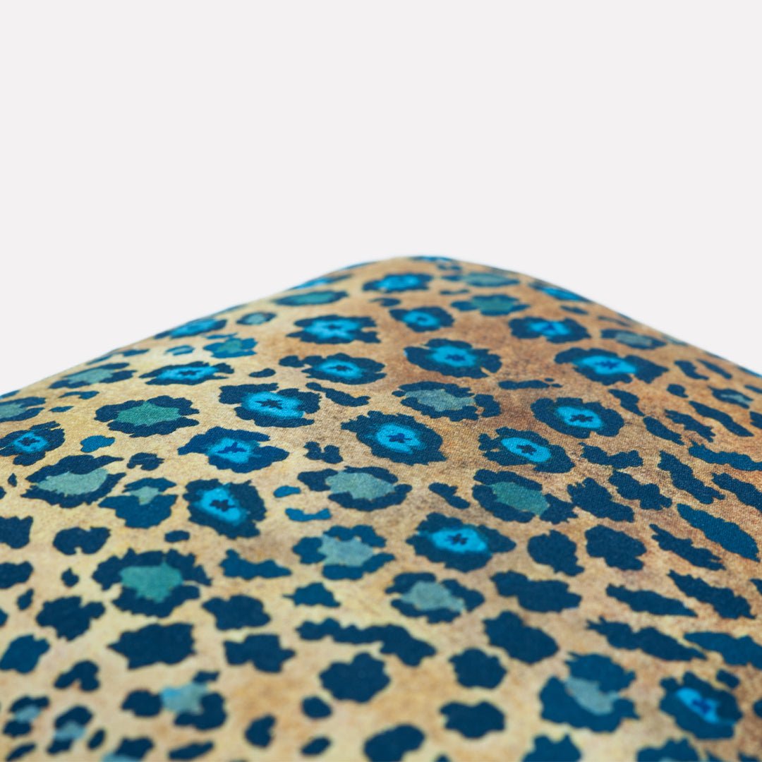 Close-up of the leopard-print texture on the Thanda Safari Spot Midnight Cushion Cover, highlighting its vibrant blue and golden hues.