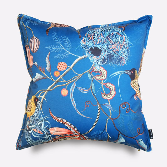 Front view of the Thanda Nests Midnight Outdoor Cushion Cover, featuring a striking blue background with intricate bird nest-inspired botanical designs in orange and gold.