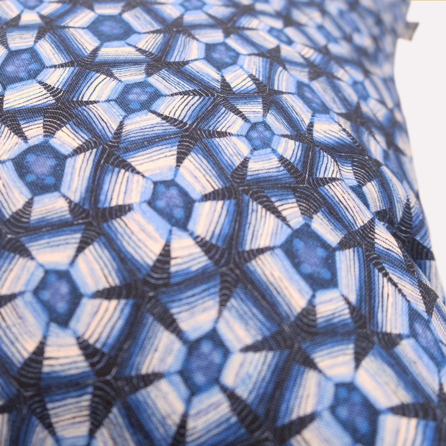 Angled view of the cushion’s backside, revealing the full geometric pattern with smooth texture and fine textile craftsmanship.