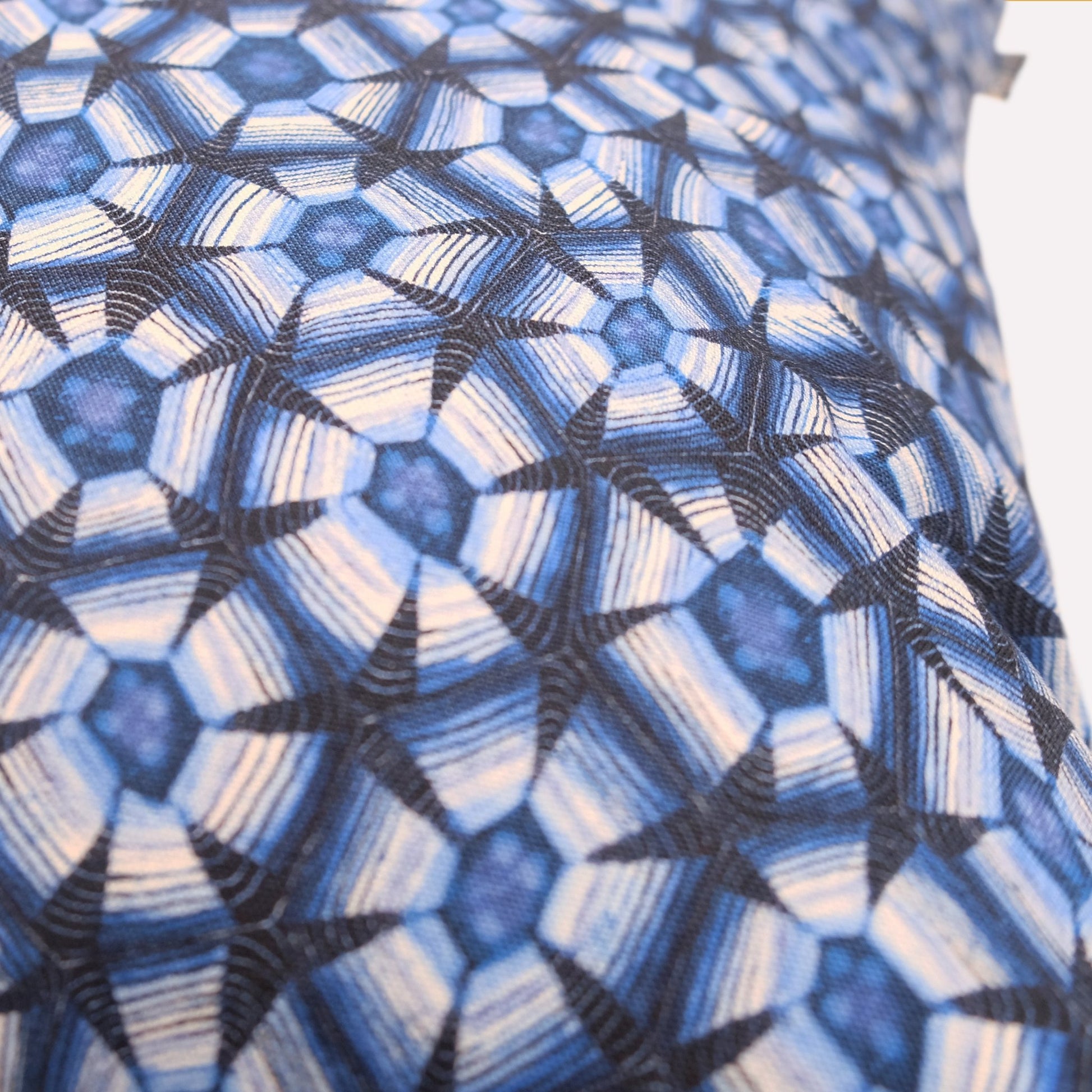Angled view of the cushion’s backside, revealing the full geometric pattern with smooth texture and fine textile craftsmanship.