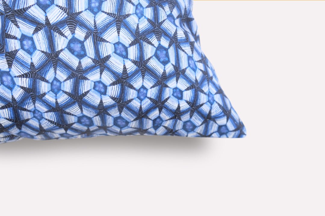 Close-up of the Thanda Tortoise Tanzanite Cushion Cover, highlighting the intricate blue patterned design and fabric texture on the cushion's corner.