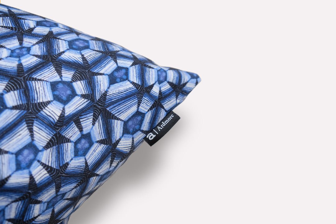 Side angle of the cushion, highlighting the detailed fabric pattern and crisp stitching on the edges.