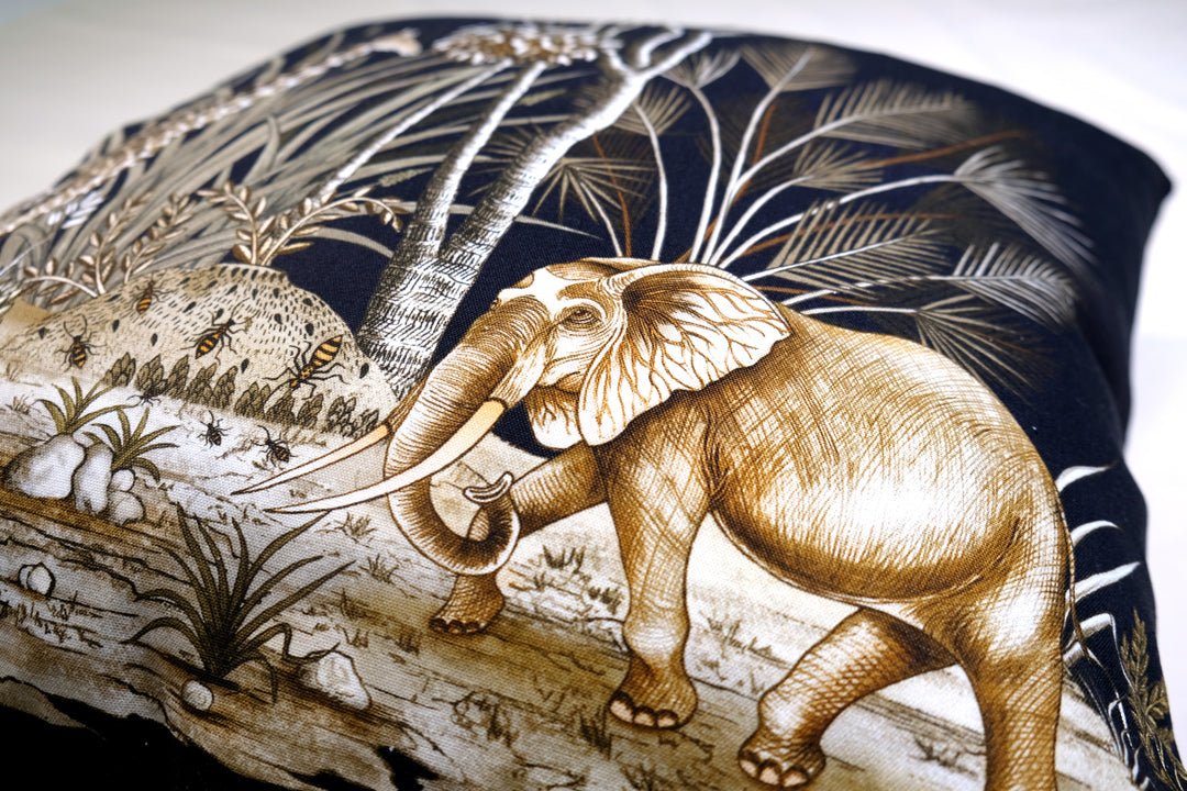A detailed close-up of the cushion, highlighting the golden tones of the elephant illustration and the rich texture of the velvet fabric.