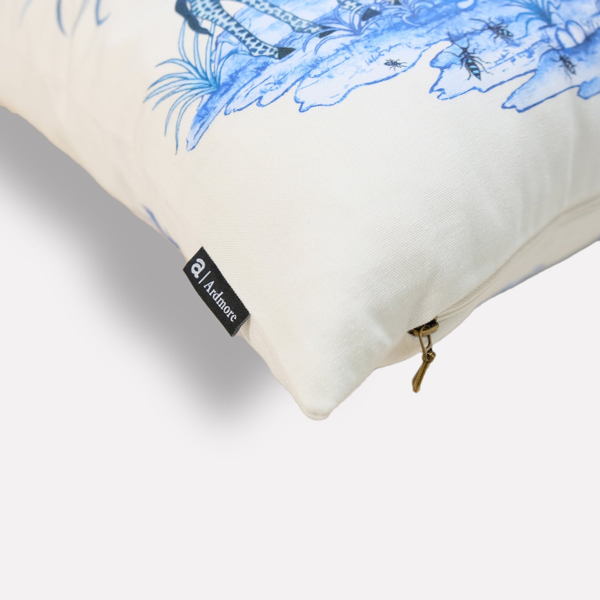 A side-angle shot of the cushion, highlighting the detailed botanical illustrations and vibrant blue color on the soft fabric.