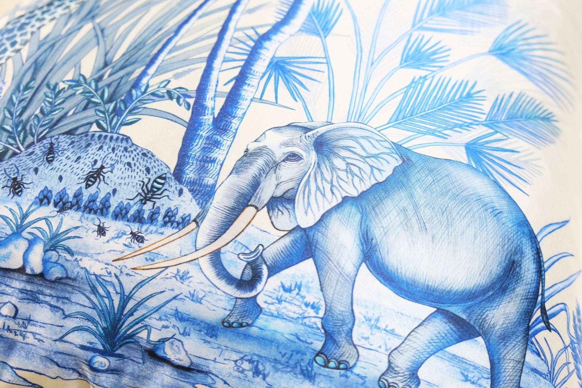 A side perspective showing the fine silk texture, the depth of the blue wildlife print, and the neat seams of the cushion.