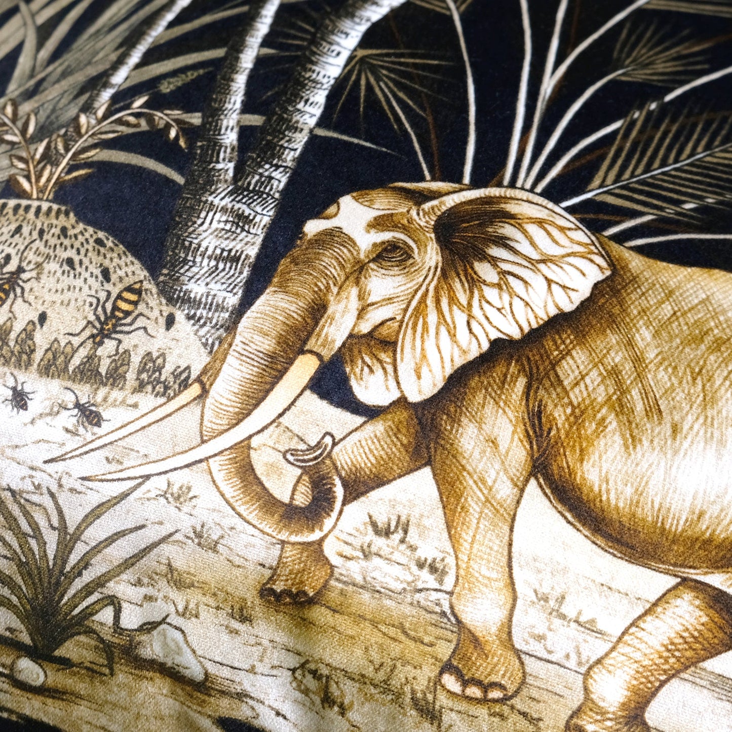 Close-up of the detailed elephant illustration on the cushion cover, highlighting the fine artistic style and golden hues.