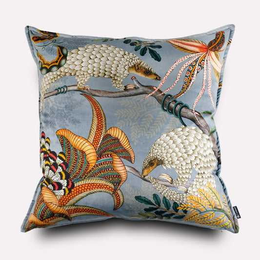 Front view of the Thanda Pangolin Park Ash Velvet Cushion Cover, showcasing a serene pangolin design on a soft grey-blue velvet background, accentuated by orange and gold foliage details.