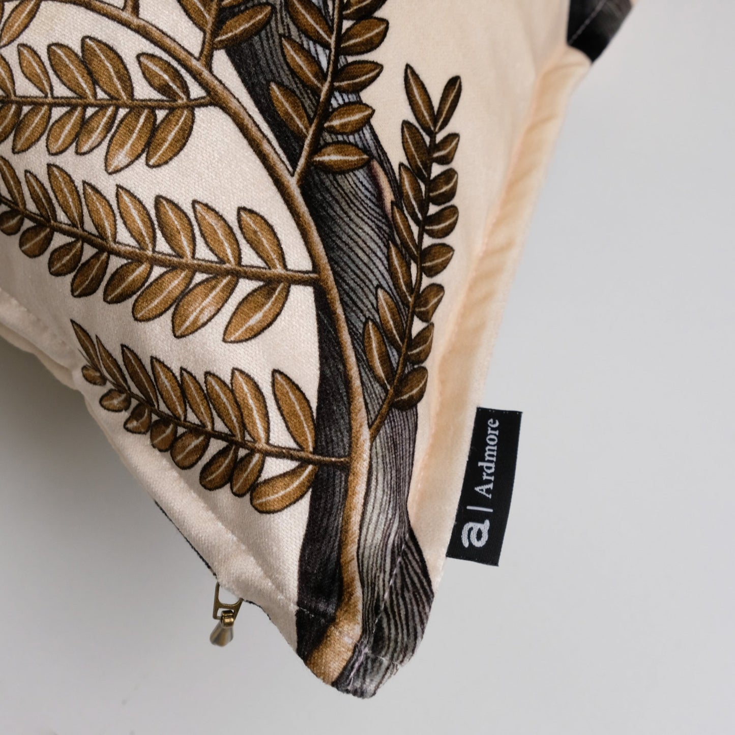 Side view of the Thanda Pangolin Park Pearl Velvet Cushion Cover, highlighting the luxurious fabric texture and intricate stitching along the edges.