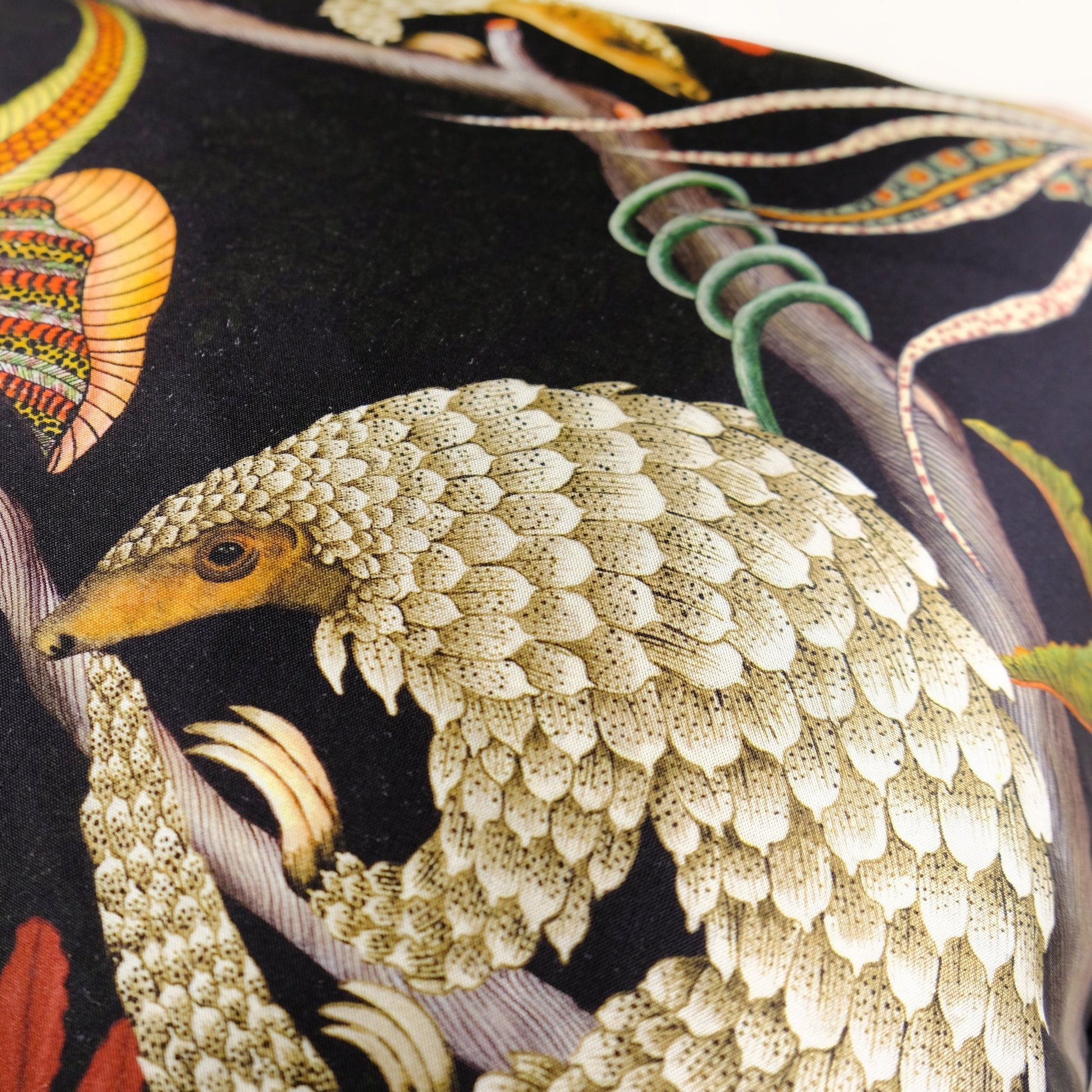 Detailed view of the pangolin design on the Thanda Pangolin in Night Silk Cushion Cover, focusing on the fine artwork and golden accents.