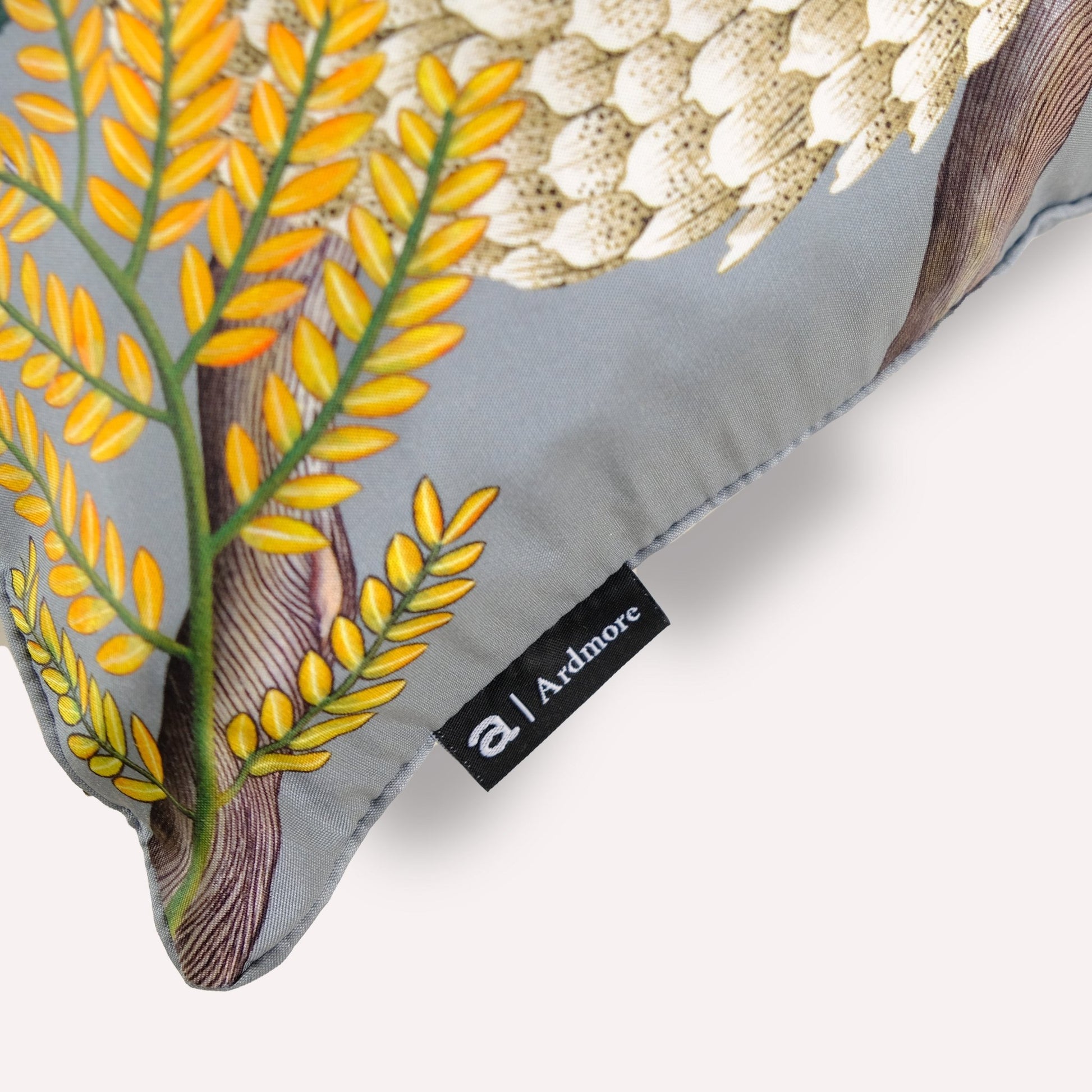 Close-up of the Thanda Pangolin in Ash Silk Cushion Cover, highlighting the intricate stitching and fine craftsmanship of the piping.