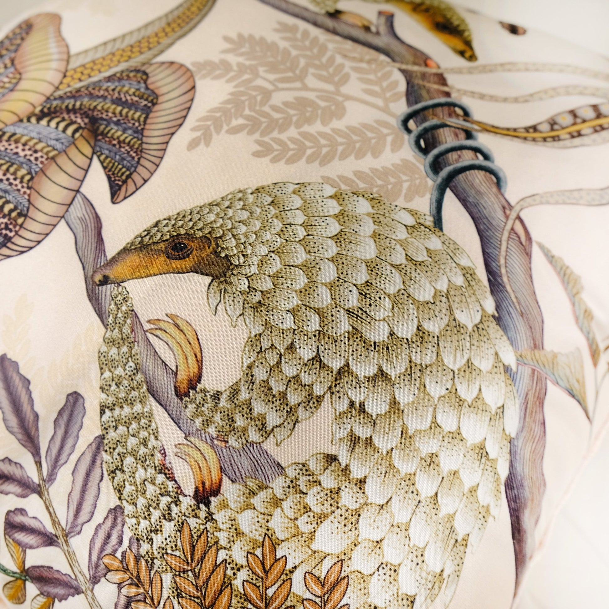 Zoomed-in detail of the pangolin artwork on the Thanda Pangolin in Pearl Silk Cushion Cover, focusing on the artistic representation and vibrant accents.