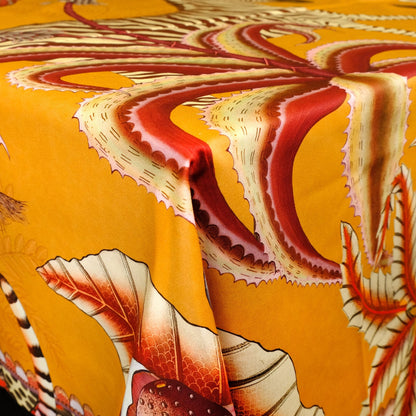 A detailed shot showcasing the tablecloth elegantly draping over the table’s edge, revealing flowing patterns of foliage and wildlife.