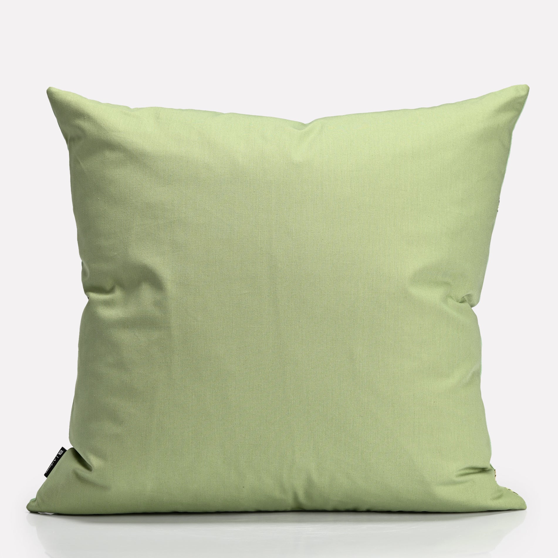 A plain light green fabric backing, providing a contrast to the detailed front design.