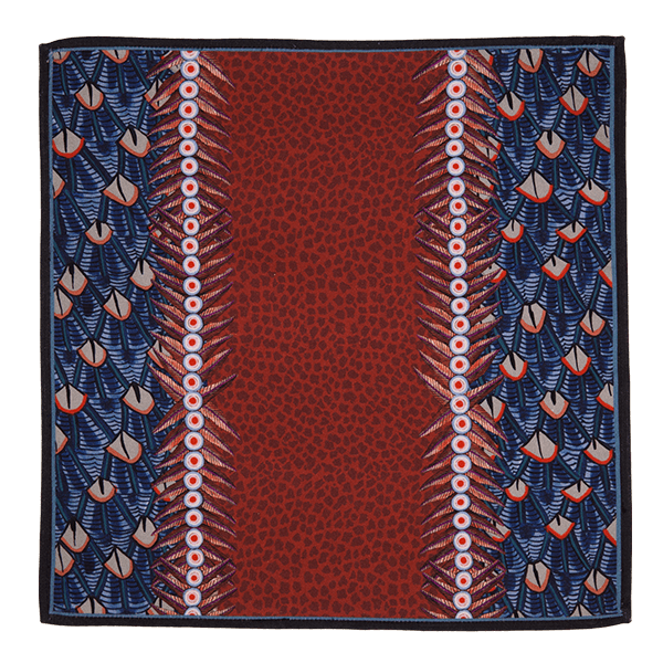 A close-up of the Ardmore Feather napkin in Royal Red, highlighting the detailed feather-like motifs and decorative border in rich red and navy tones.