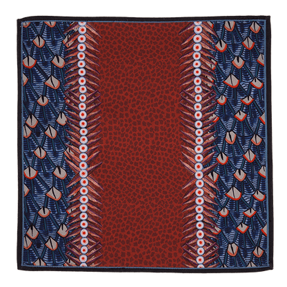 A close-up of the Ardmore Feather napkin in Royal Red, highlighting the detailed feather-like motifs and decorative border in rich red and navy tones.