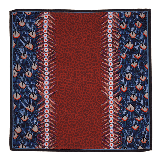 A close-up of the Ardmore Feather napkin in Royal Red, highlighting the detailed feather-like motifs and decorative border in rich red and navy tones.