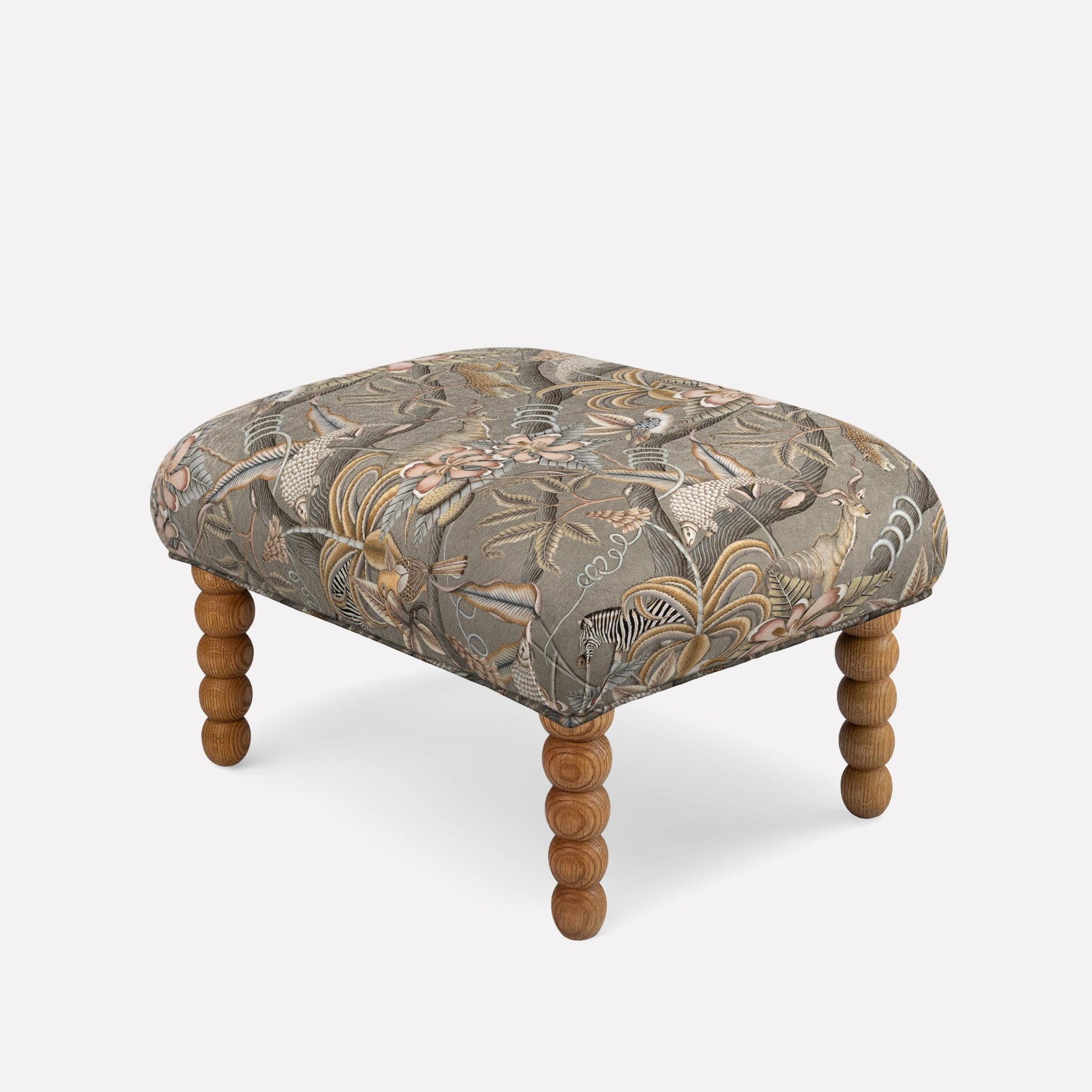 A luxurious ottoman by Ardmore, upholstered in Pangolin Park Silver Velvet, featuring a plush, shimmering silver fabric with an intricate pattern inspired by pangolin scales. The sumptuous blend of 66% cotton, 31% viscose, and 3% polyester enhances both comfort and durability. Supported by finely crafted wooden legs, this ottoman exemplifies Ardmore's signature fusion of African artistry and contemporary sophistication, making it a refined statement piece for any elegant interior.