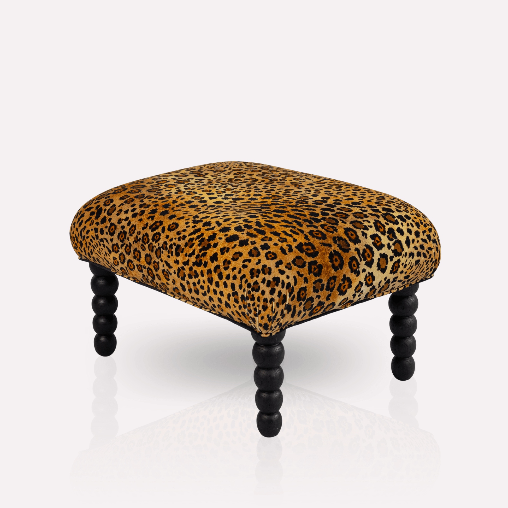 A luxurious Kudu Pod Ottoman from Ardmore, upholstered in Safari Spot Gold Velvet. The gold-toned velvet fabric with exotic leopard print creates a striking and elegant statement piece.