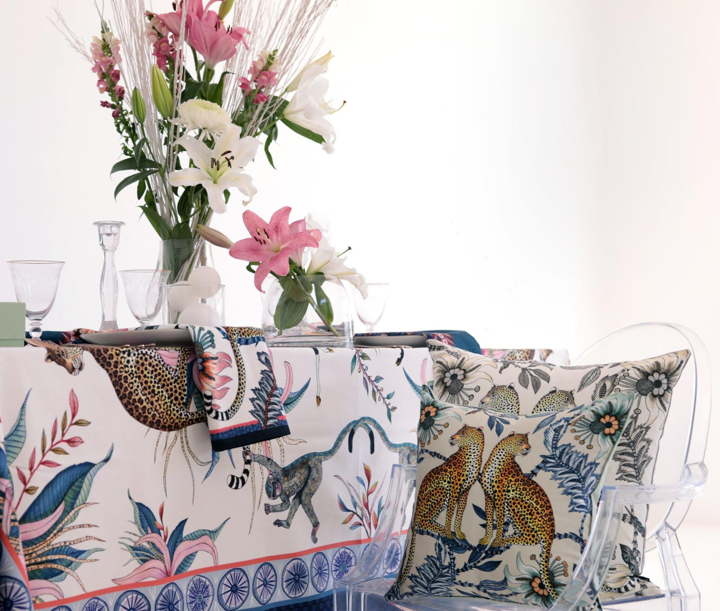 A refined dining setup with the Leopard Lily Square tablecloth draped over a table, complemented by a floral arrangement and elegant decor.