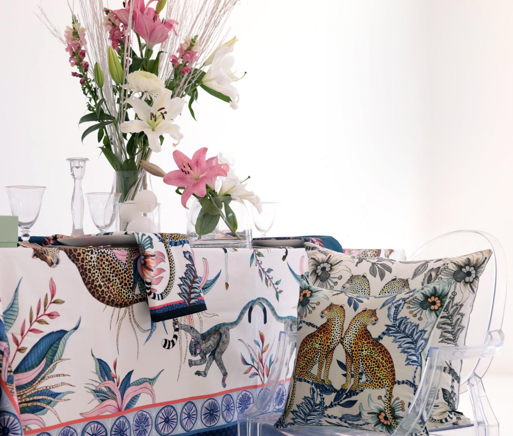 A refined dining setup with the Leopard Lily Square tablecloth draped over a table, complemented by a floral arrangement and elegant decor.