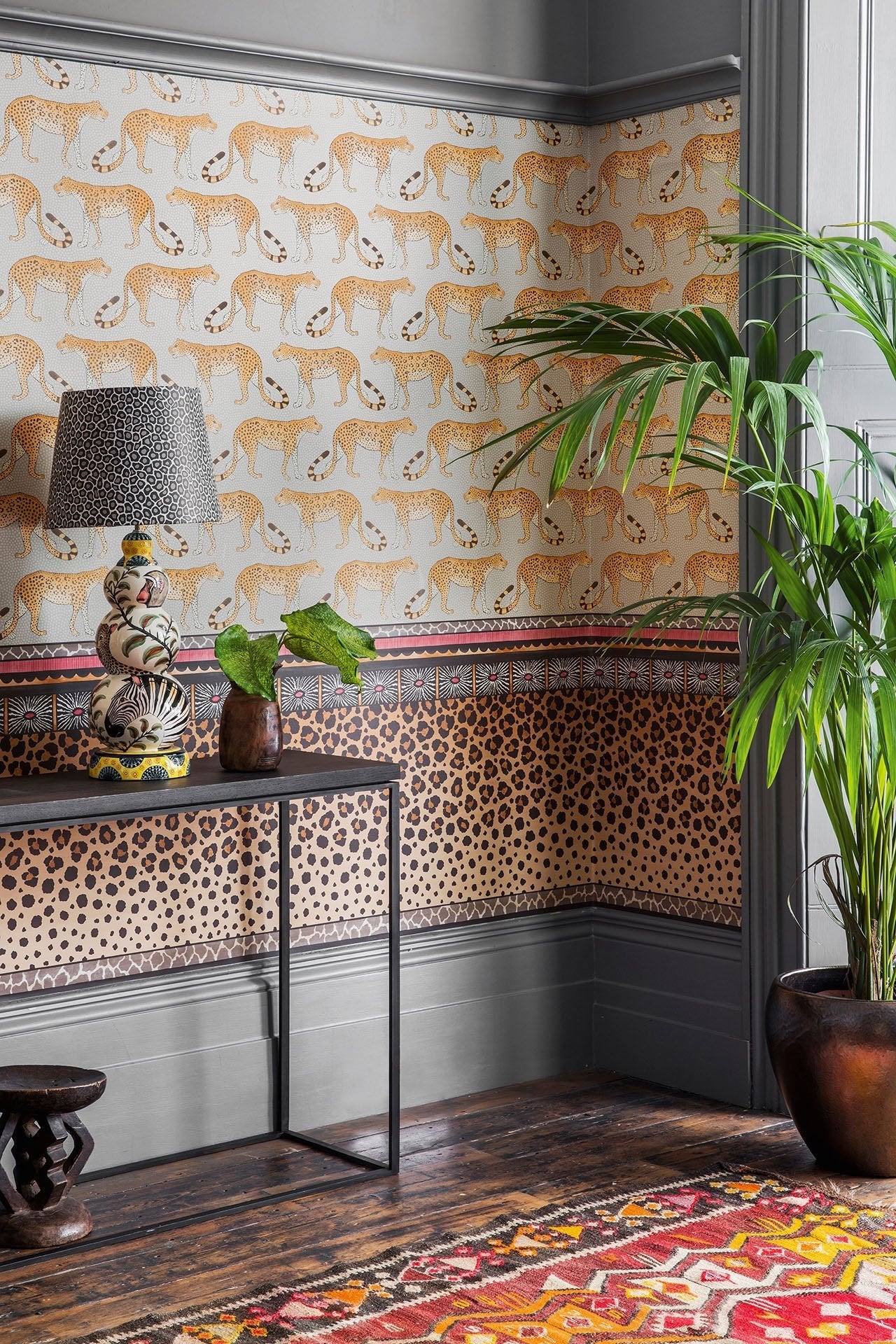 A beautifully decorated interior showcasing the Leopard Walk wallpaper, complemented by warm wooden furniture and elegant décor.