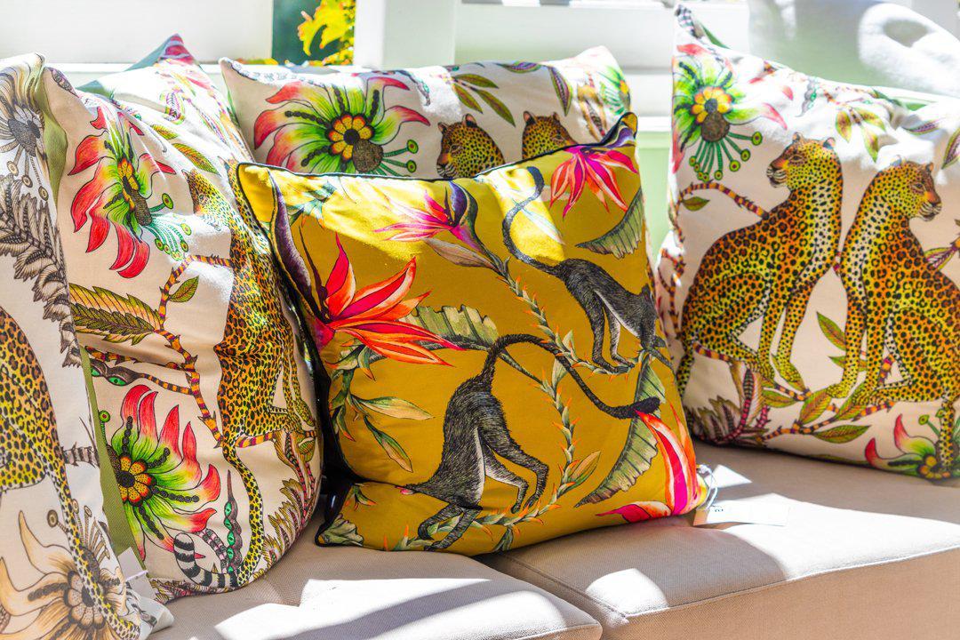 Display of multiple Lovebird Leopards Parakeet cushion covers arranged together, showcasing the vibrant patterns and colours.