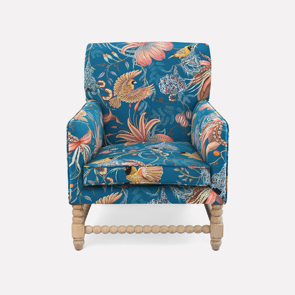 The Ardmore Lucky Bean Chair, upholstered in Thanda Nests Midnight Linen, features a vibrant botanical design inspired by African artistry. Its plush seat, high backrest, and curved armrests provide both luxury and comfort, making it an exquisite centrepiece for refined interiors.