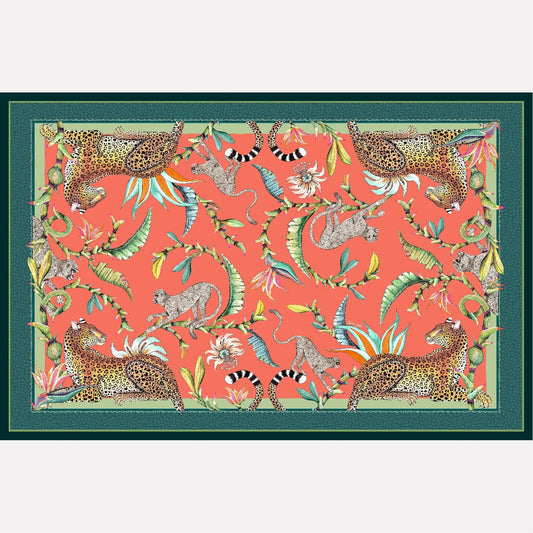 A flat lay of the Monkey Paradise Tablecloth in Coral, featuring a vibrant coral background with detailed illustrations of monkeys, leopards, passion flowers, and birds of paradise.