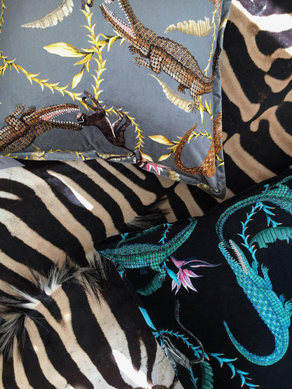 Styled view of the River Chase Silver Ripple Velvet Cushion Cover paired with other luxurious cushions, set against a zebra-patterned chair for a sophisticated décor look.