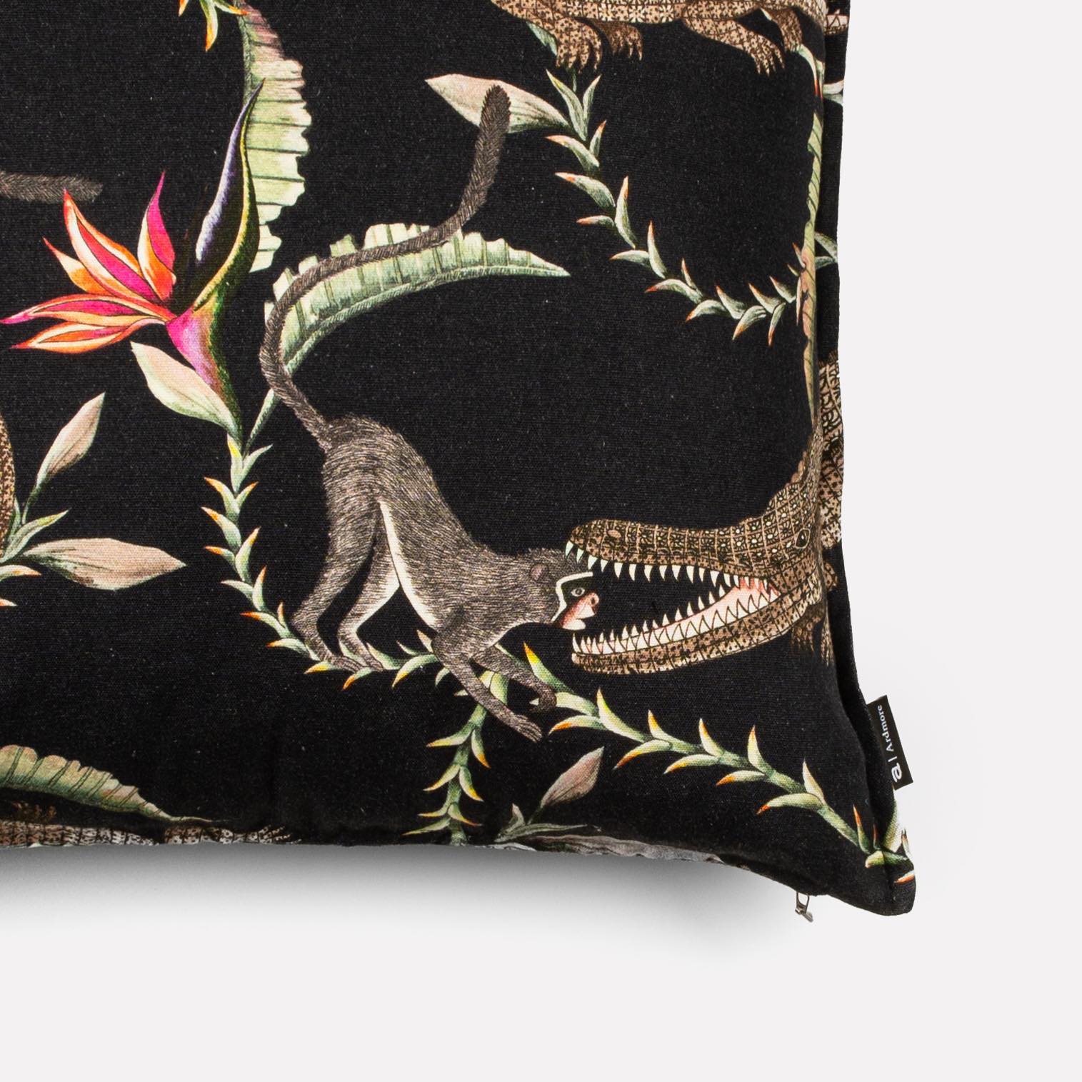 Close-up view of the River Chase Night Linen cushion cover, highlighting the intricate crocodile details and vibrant flower accents.