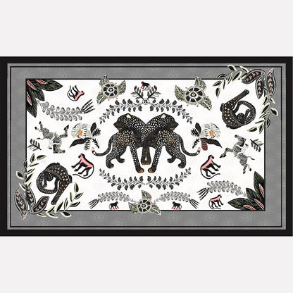 A flat-lay view of the Royal Leopard Tablecloth in Charcoal on Natural Linen, featuring an intricate black-and-white elephant and leopard motif with botanical elements.