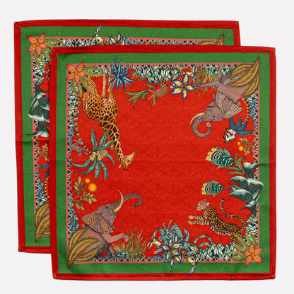 A display of two Ardmore Sabie Forest Napkins in Royal Red stacked together, highlighting the ornate green border and the intricate jungle-inspired patterns.