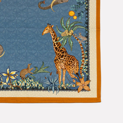A close-up of the intricate Ardmore Sabie Forest napkin print, showcasing its vibrant Tanzanite hue, detailed African wildlife motifs, and elegant satin weave finish.