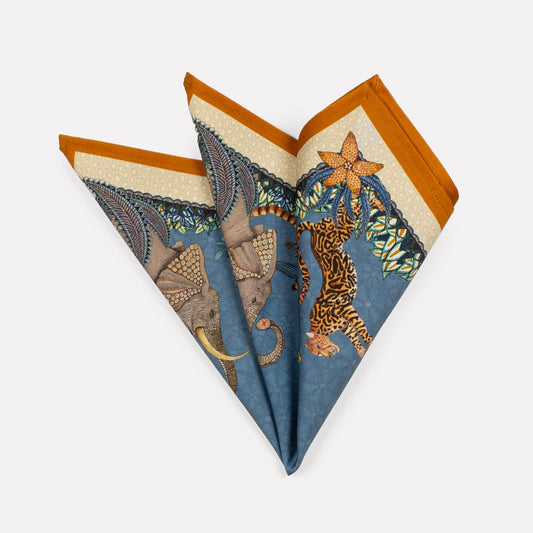 A set of three neatly folded Sabie Forest napkins in Tanzanite, featuring intricate African-inspired patterns with rich blue and gold hues.
