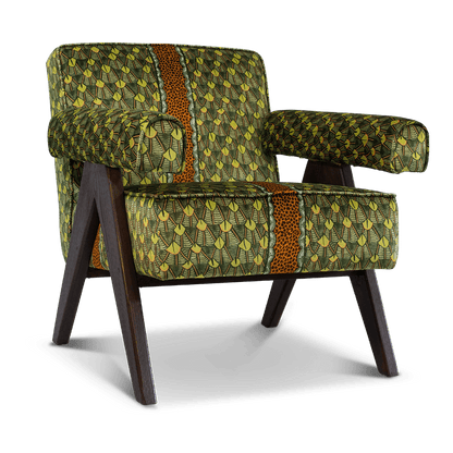 A three-quarter angle shot, showcasing the chair’s structured silhouette, plush armrests, and modern wooden legs.