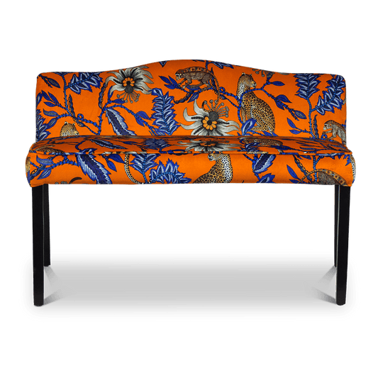 A straight-on shot of the Zambezi Monkey Bean Flame Bench, upholstered in a striking orange and blue velvet fabric, featuring intricate African-inspired patterns and a modern silhouette.