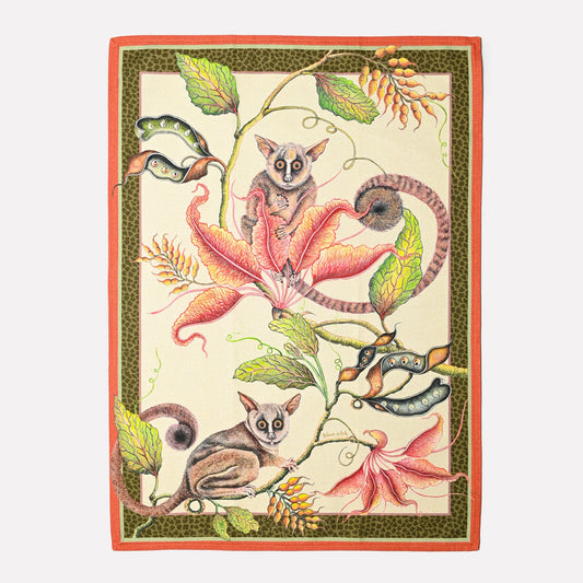 A beautifully designed tea towel featuring playful bush babies swinging among lush foliage, framed with an elegant border.