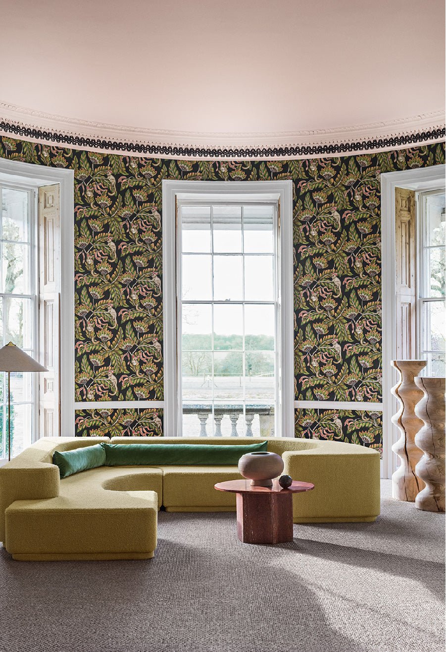 A luxurious interior featuring Bush Baby wallpaper, where rainforest greens and bursts of scarlet create a warm and vibrant aesthetic.