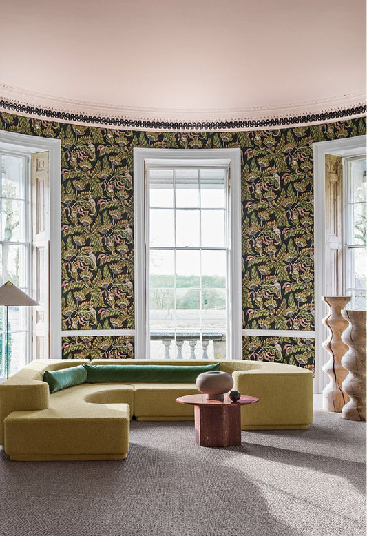 A luxurious interior featuring Bush Baby wallpaper, where rainforest greens and bursts of scarlet create a warm and vibrant aesthetic.