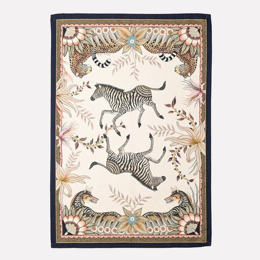 A luxurious tea towel featuring an intricate print of leopards and jackals roaming amidst African-inspired foliage, framed by an elegant patterned border.